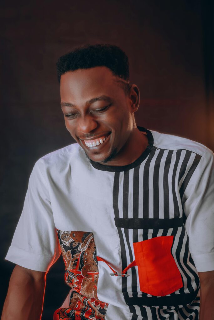 Portrait of a smiling African American man wearing a creative patterned shirt, exuding happiness and style.