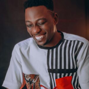Portrait of a smiling African American man wearing a creative patterned shirt, exuding happiness and style.