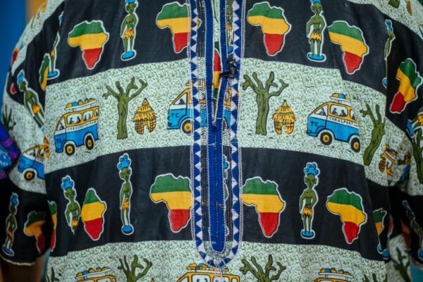 Close-up of vibrant African patterned fabric featuring cultural symbols and colorful designs.